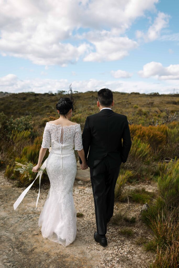 Couple walking through long grass. Engaged couple having an engagement session at the top of the blue mountains