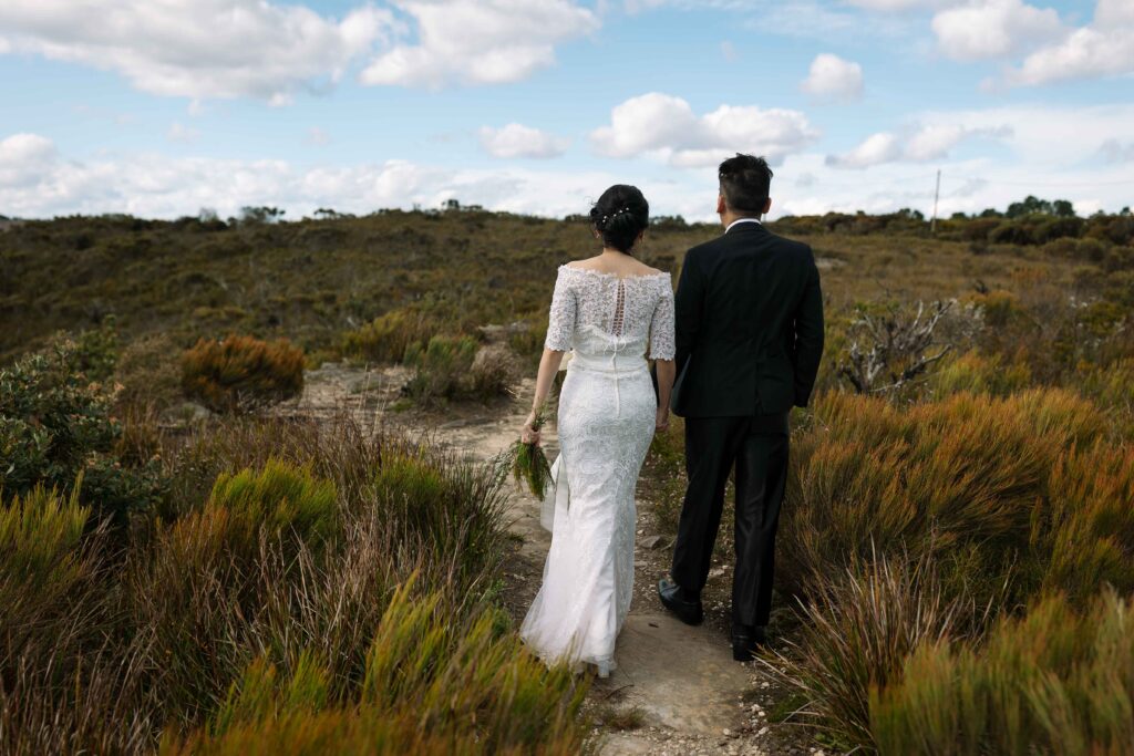 Couple walking through long grass. Engaged couple having an engagement session at the top of the blue mountains