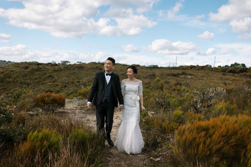Couple walking through long grass. Engaged couple having an engagement session at the top of the blue mountains