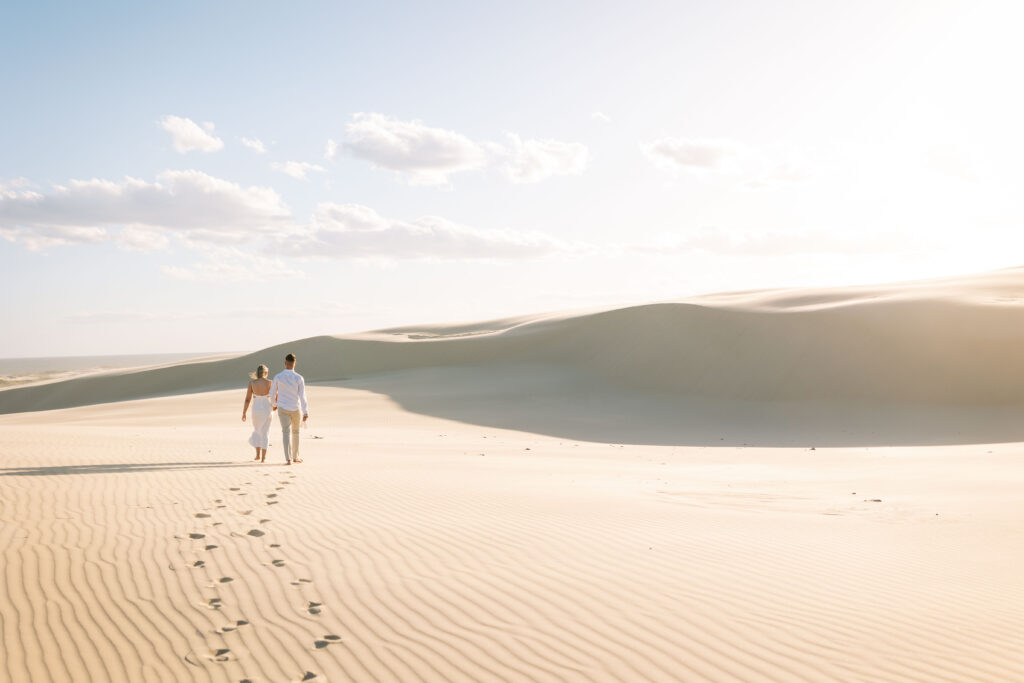 Engagement session sunset at Stockton sand dunes. Footprints in the sand