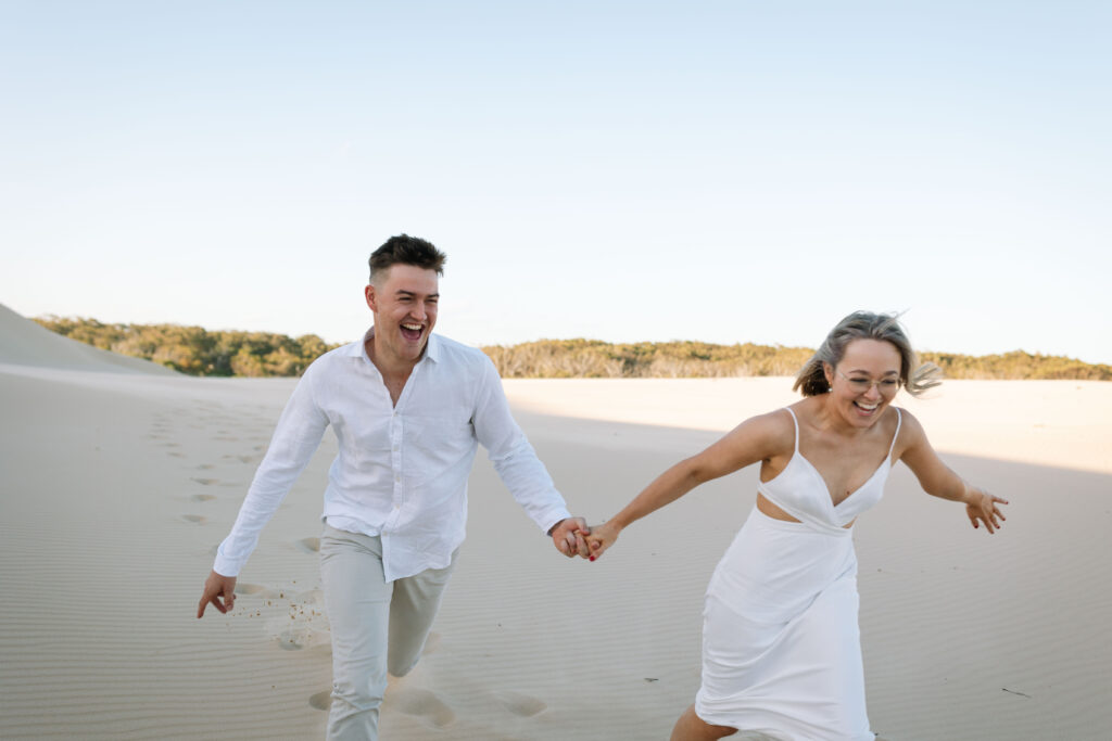 Engagement session sunset at Stockton sand dunes. Couple running