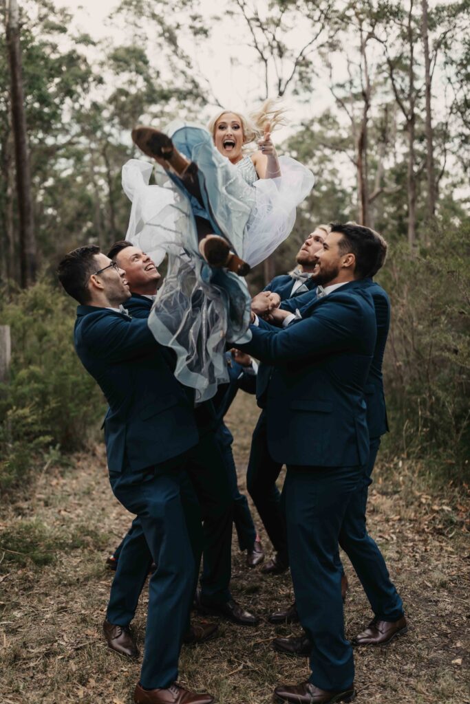 bride being thrown in the air by groomsmen