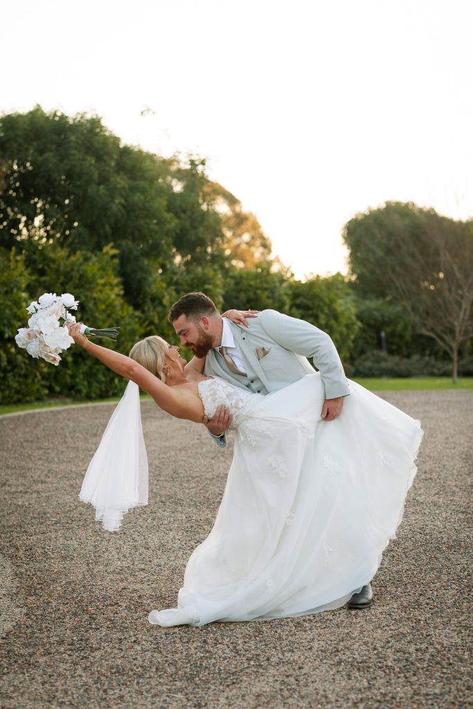 husband giving his wife a dip with her flowers in the hunter valley