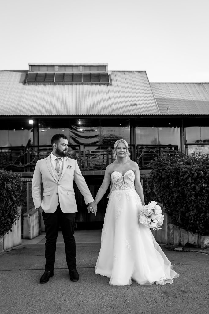 husband and wife standing together holding hands at their wedding in the hunter valley