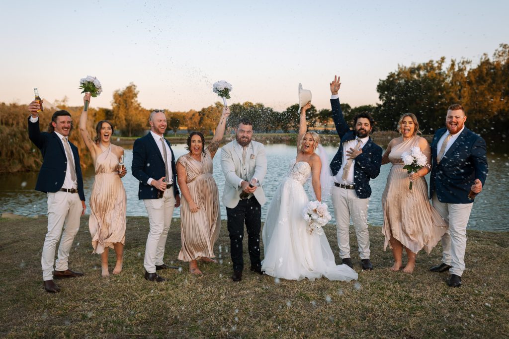 bridal party celebrating popping and spraying champaign at their wedding in the hunter valley