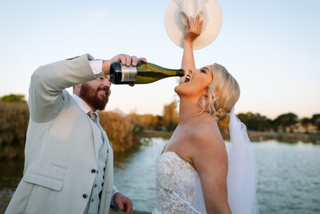 husband pouring champaign in brides mouth at heir wedding in the hunter valley