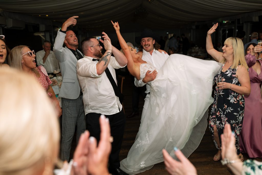 bride being picked up by the boys at a wedding reception in the hunter valley