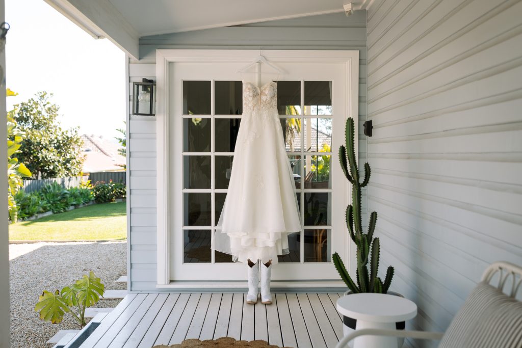 Bride's dress hanging on a door at bridal prep in the hunter valley